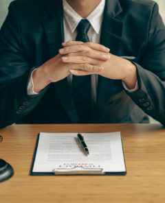 Concepts of justice and lawyers discuss contract paperwork with brass scales on a table with a judge's hammer placed in front of lawyers in the office. Legal, advice, justice, and conceptual services.