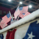 Elections in the United States of America. Close up of table for voting registration with American flags standing at polling place. Presidential race and election coverage. Civic duty and patriotism.