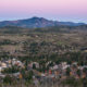 Aerial view of the town of Santa Rosa, California, nestled in a valley at sunset beneath a mountain. Rural community in Sonoma County wine country at dusk.