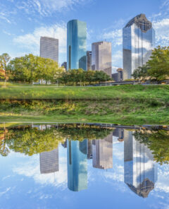 scenic skyline of Houston, Texas in morning light seen from Buffalo bayou park and reflection in river