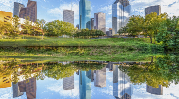 scenic skyline of Houston, Texas in morning light seen from Buffalo bayou park and reflection in river