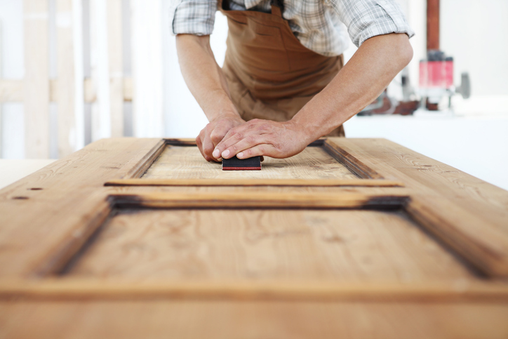 carpenter work the wood with the sandpaper